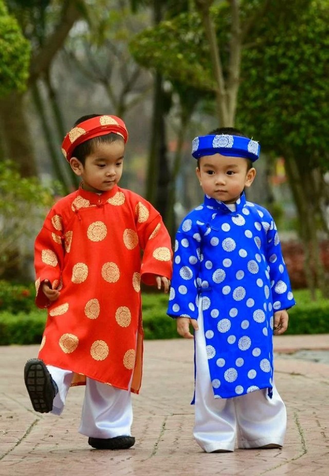 赤と青のアオザイを着ているベトナム人の子供